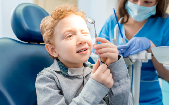 chłopiec trzymający lusterko dentystyczne